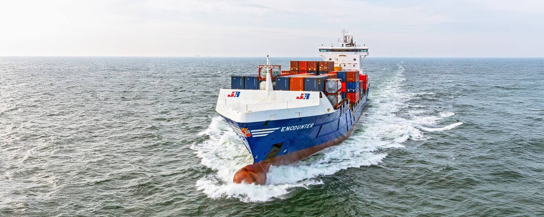 Een containerschip van JR Shipping onderweg op zee.