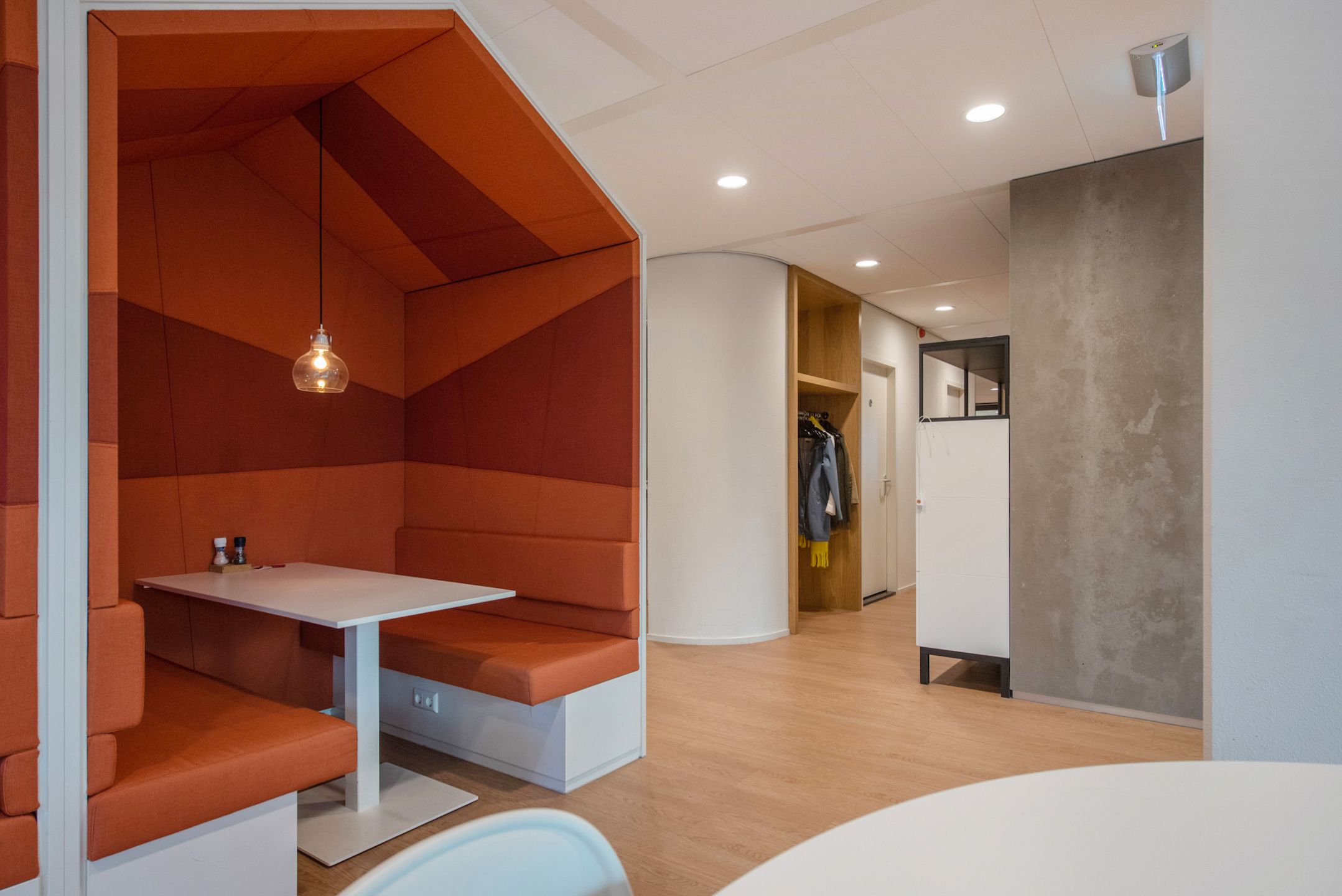 An upholstered break-out booth beside the building's café area.